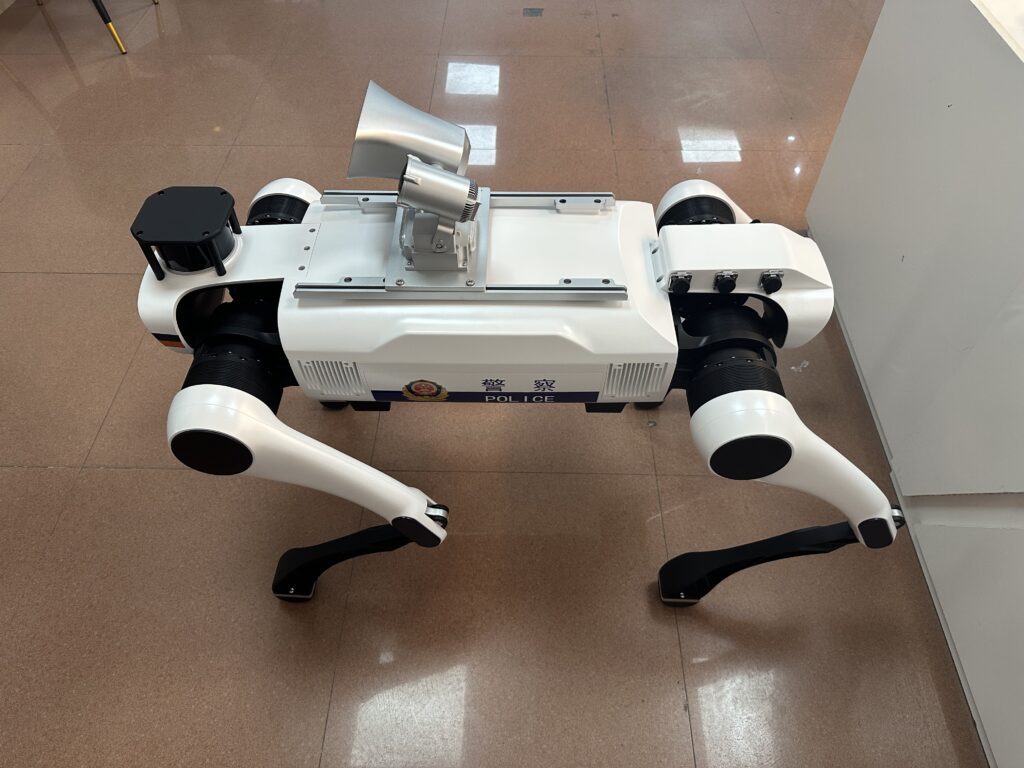 Front LiDAR array and transparent acrylic visor assembled on a law enforcement robot dog casing.